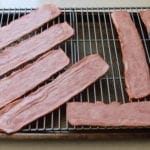 Running bacon under cold water helps to reduce its shrinking. Add a little stevia to each slice and candied bacon is born!
