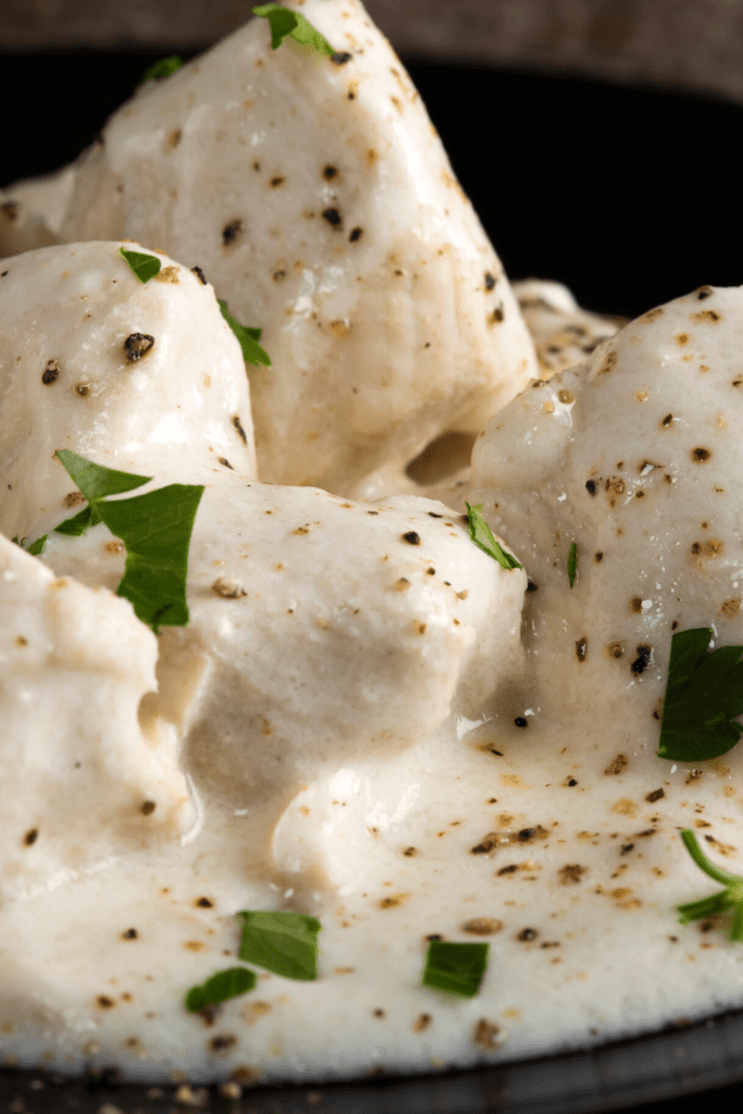 Chicken with cauliflower garlic cream sauce over it.