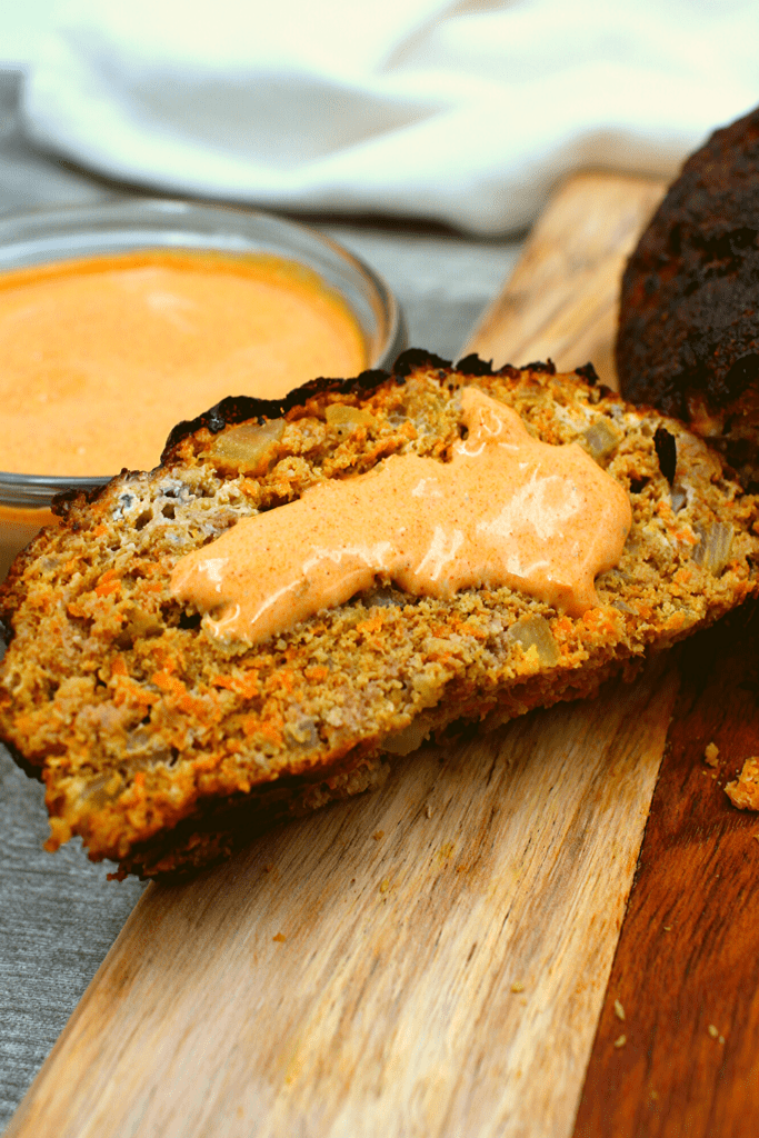 A slice of keto buffalo chicken meatloaf with a drizzle of hot mayo sauce.
