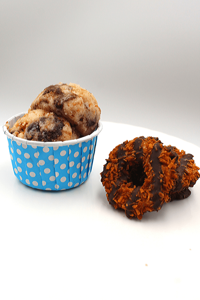 A bowl of keto samoa cookie dough beside a Girl Scout samoa cookie