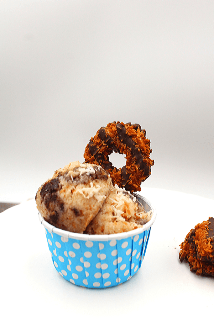 A samoa Girl Scout cookie in a bowl of gluten-free and keto samoa cookie dough