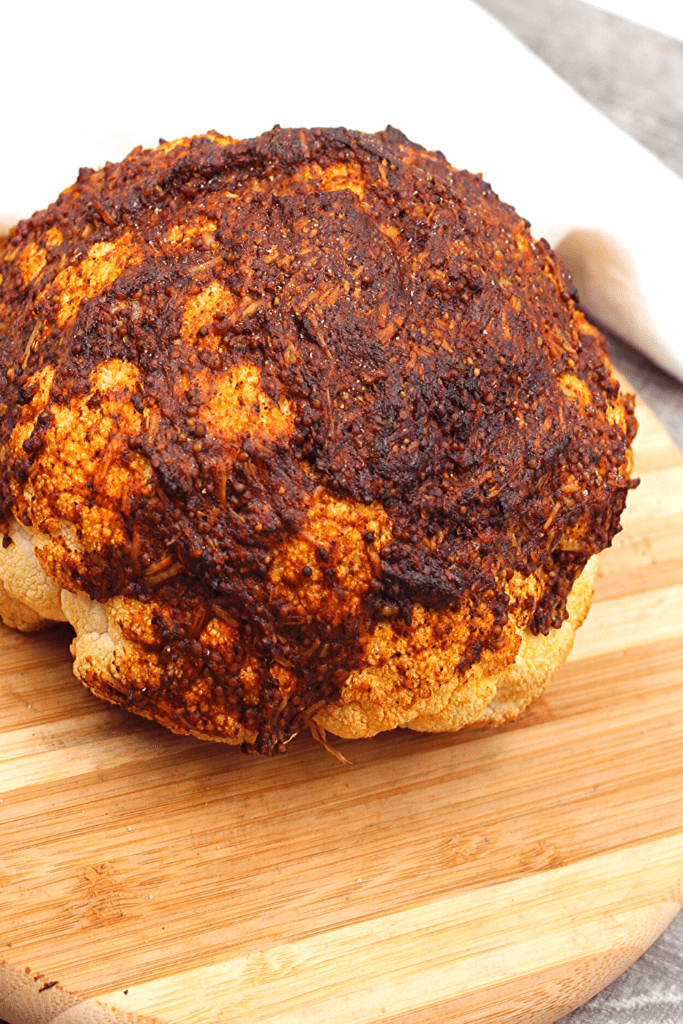 Nicely browned Parmesan coating a head of cauliflower