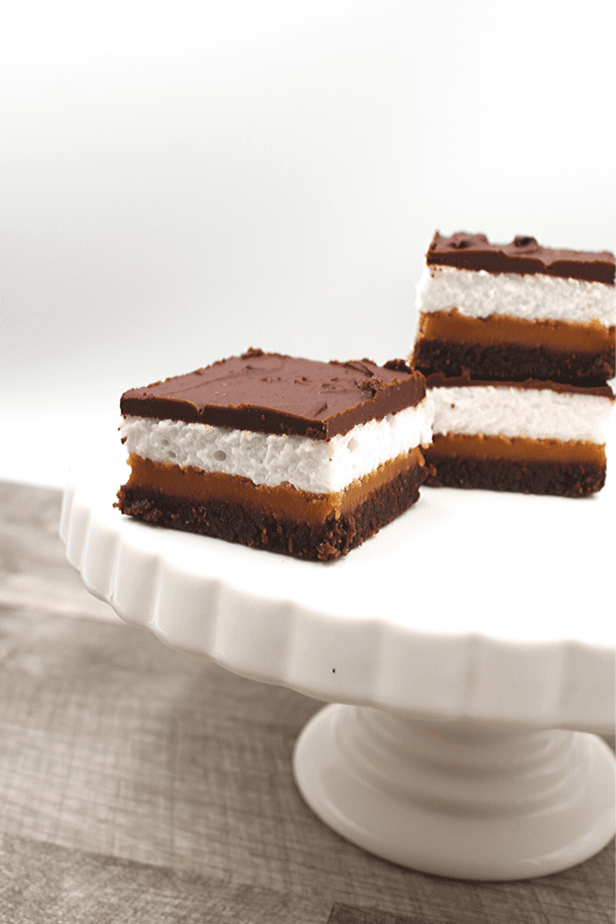 A dense keto brownie topped with peanut butter fudge and then layered with a marshmallow top.