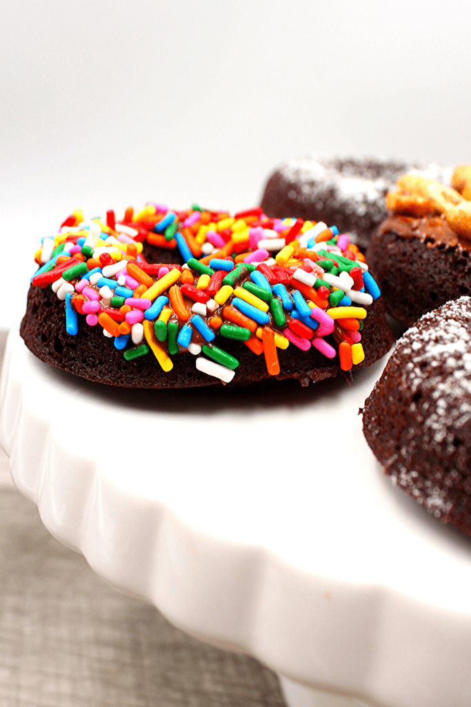 Chocolate glazed gluten-free Nutella doughnut with rainbow sprinkles.