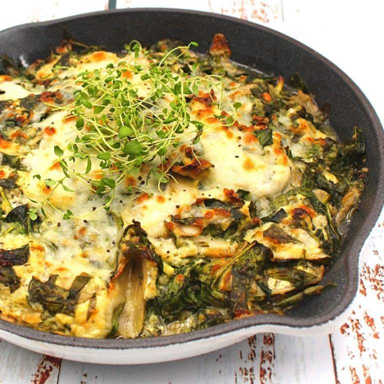 a skillet filled with chicken and artichokes