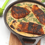 creamy fish in a skillet with Spinach
