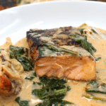 a slice of salmon in cream sauce