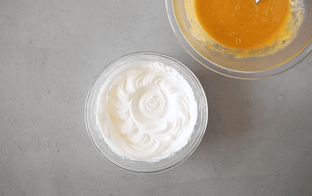 a bowl with whisked egg whites, cream of tartar and sweetener