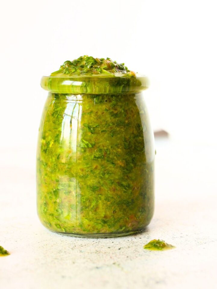 a front view of a glass jar with keto chimichurri sauce that is cilantro-free