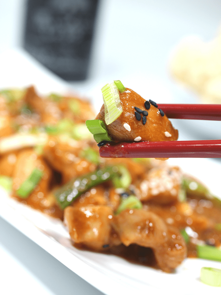 a bite of low carb mongolian chicken with chopsticks