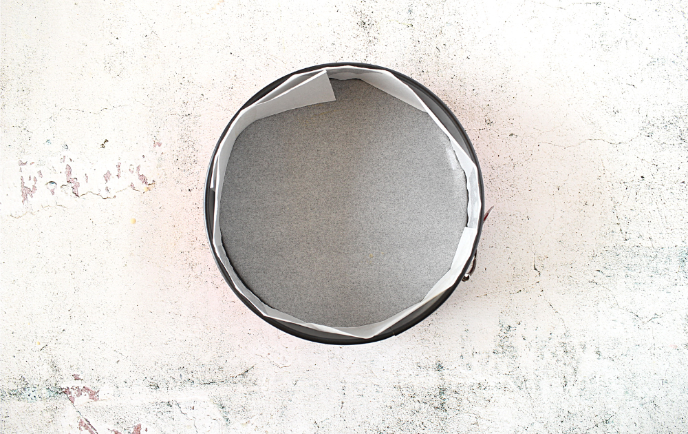 step 2 involves preparing the pan by lining the springform pan with parchment paper