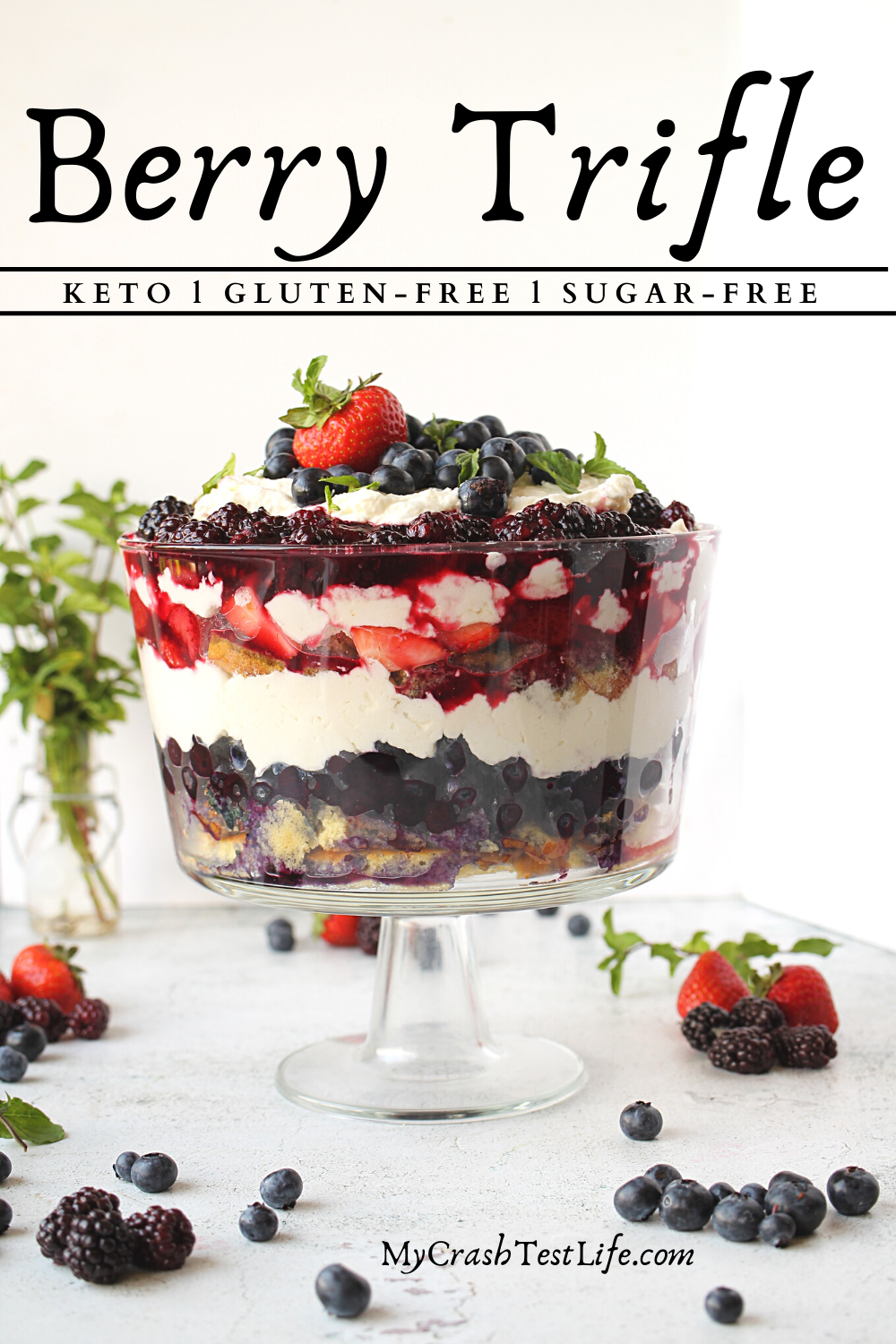 almond sponge cake layered with berries and whipped cream in a trifle bowl