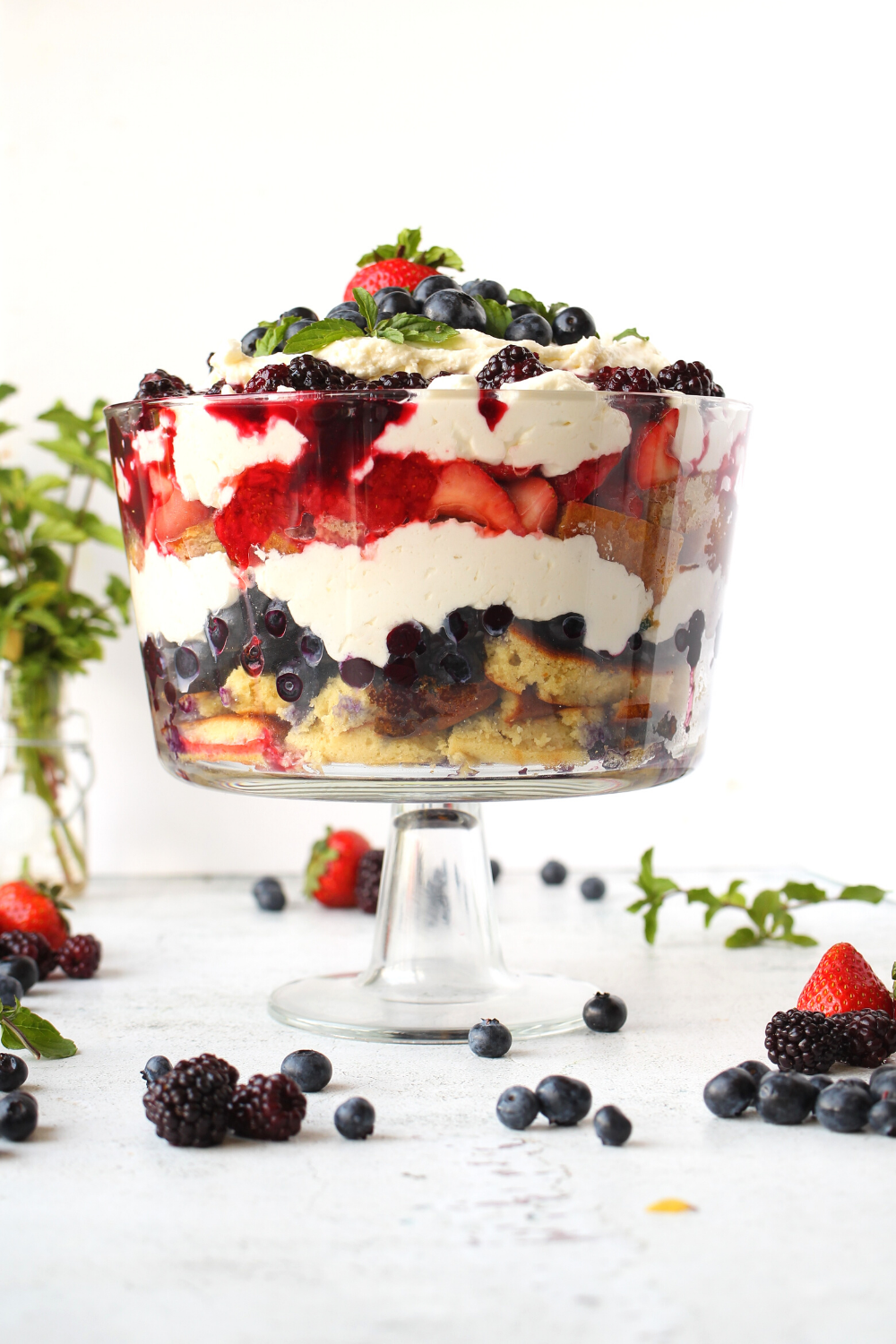 keto trifle with almond sponge cake and layers of red, white and blue summer berries