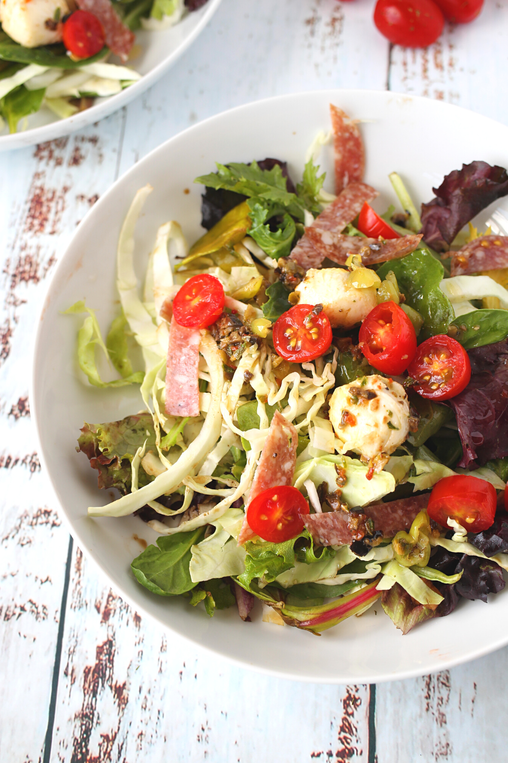 a bowl of healthy keto salad with mozzarella and sliced salami