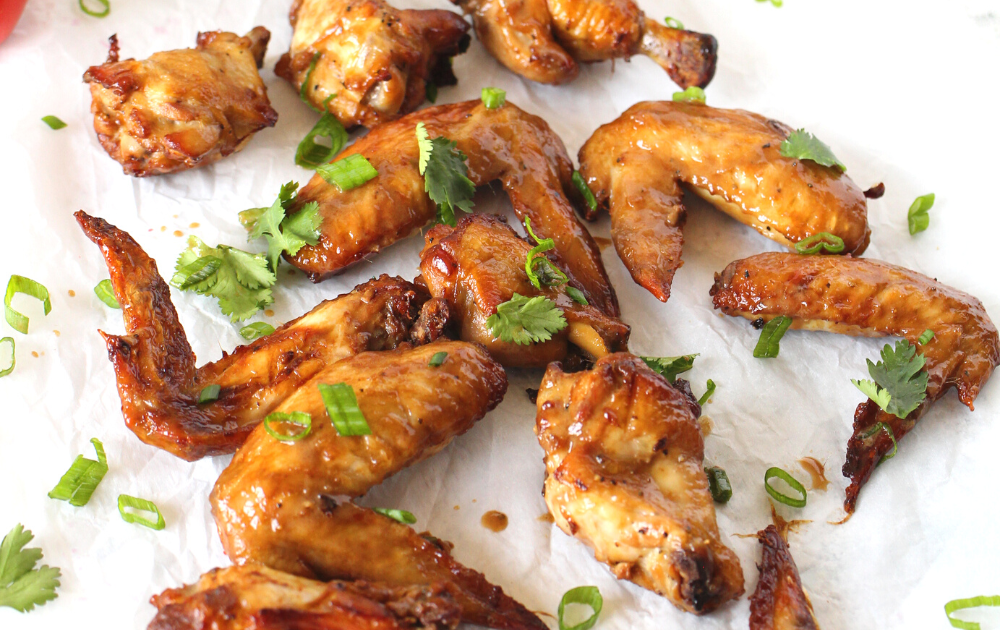 Add the keto baked wings to a bowl with reduced marinade and toss to coat.  