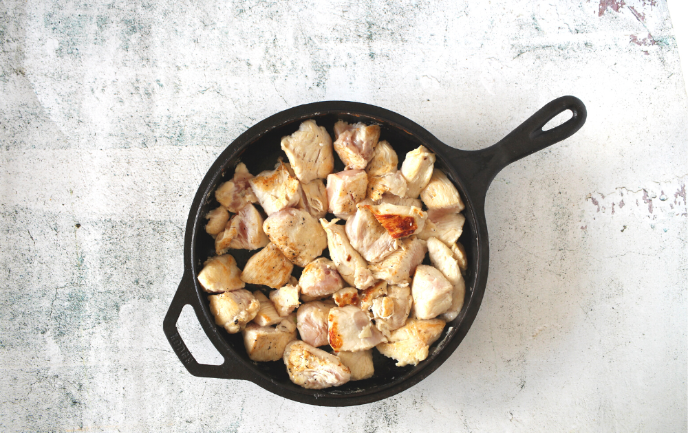 Add the cut chicken to a greased skillet and cook on medium high heat until the shicken begins to brown, about 3 minutes.  Turn the chicken and brown the other side, about 2 minutes.