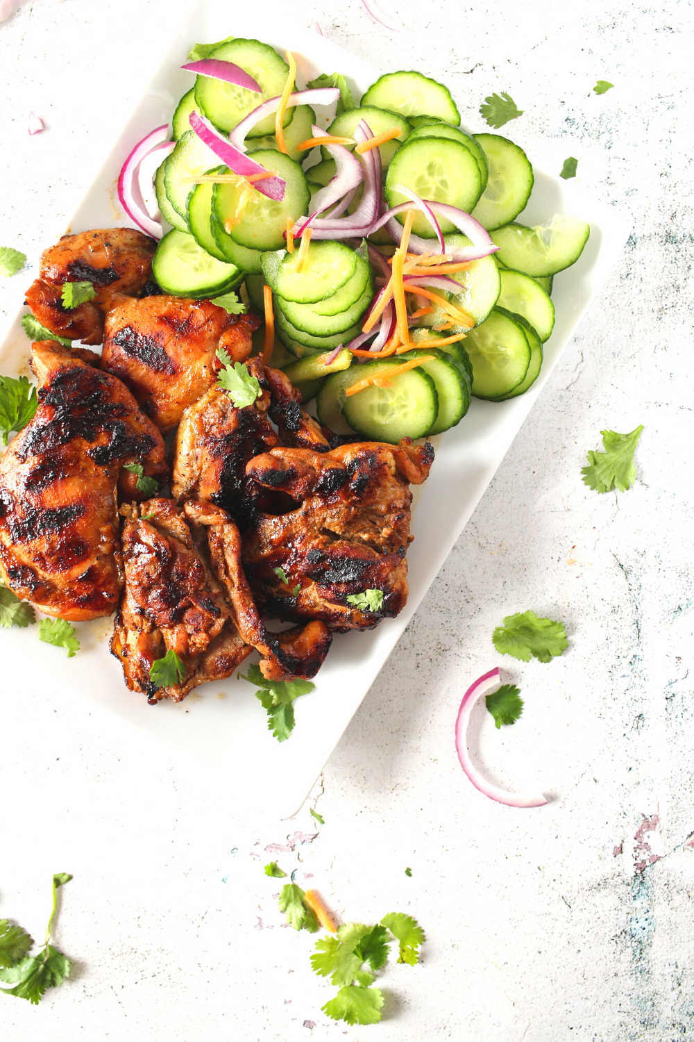 a plate of keto Chinese BBQ chicken with a side of pickled vegetables
