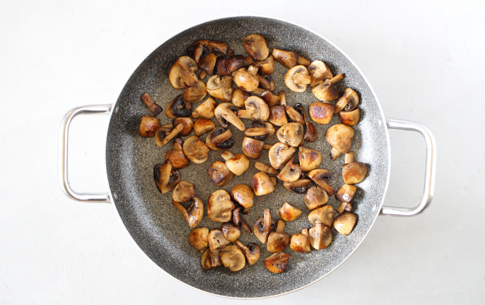 Melt the butter in a large saute pan.  Add the quartered mushrooms.  Let the mushrooms brown on one side (about 3-5 minutes) before stirring.  Cook on medium-high heat until all the sides of the mushrooms have been caramelized.