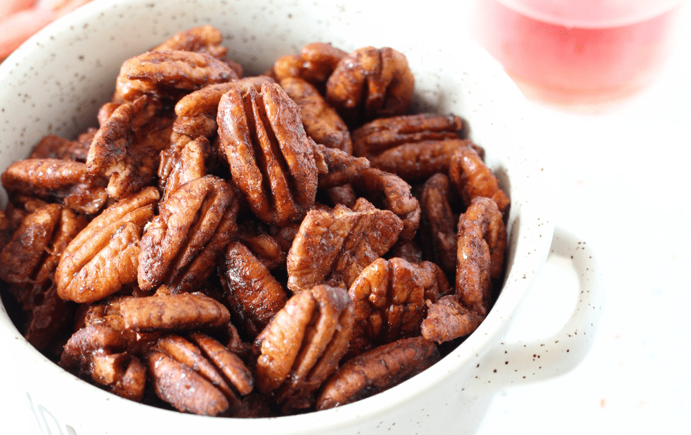 a bowl of fresh candied walnuts coated in a spicy sugar-free shell