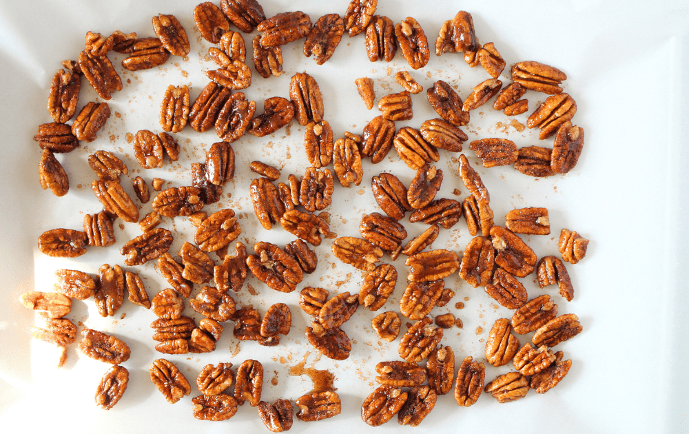 top view of keto spicy maple candied nuts spread on a sheet of parchment paper before baking
