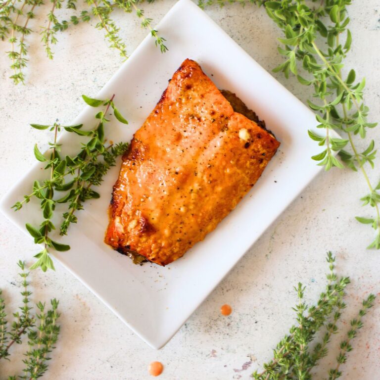 top view of an easy keto air fryer recipe for one using salmon and a keto bang bang sauce with herbs