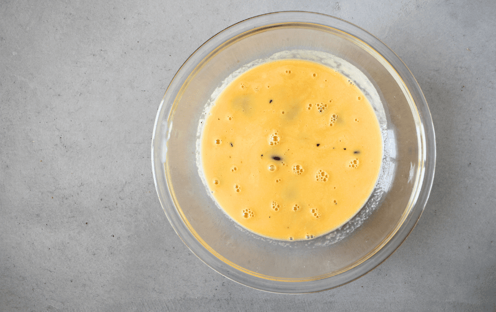 top view of hot egg mixture poured over sugar-free chocolate to melt the chocolate for the keto semifreddo