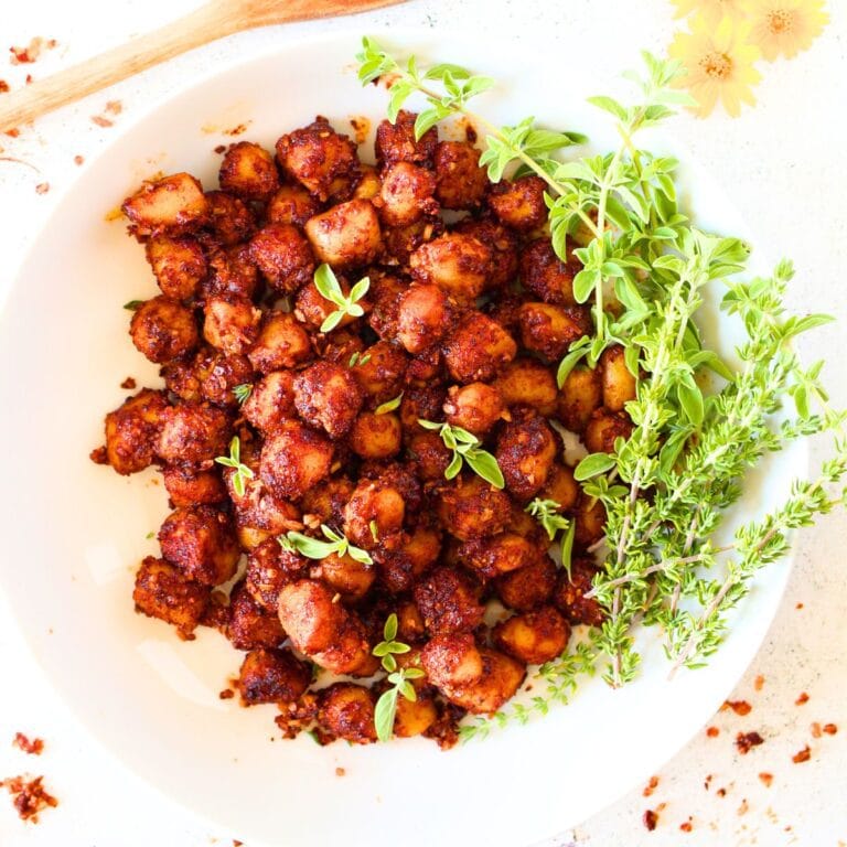 top view of Air Fryer Spicy Bay scallops with herbs and a wooden spoon