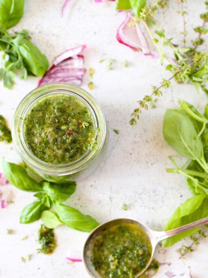 a jar filled with a keto herb dressing made with red onion, vinegar and leftover fresh herbs