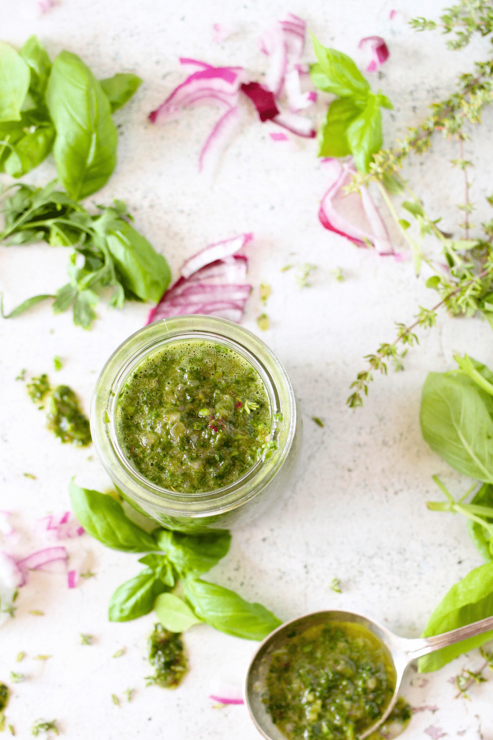 a jar filled with a keto herb dressing made with red onion, vinegar and leftover fresh herbs