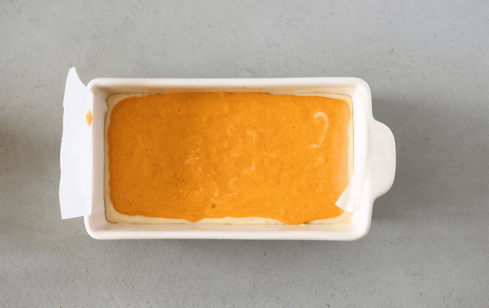 top view of a loaf pan with the final keto pumpkin layer before being baked