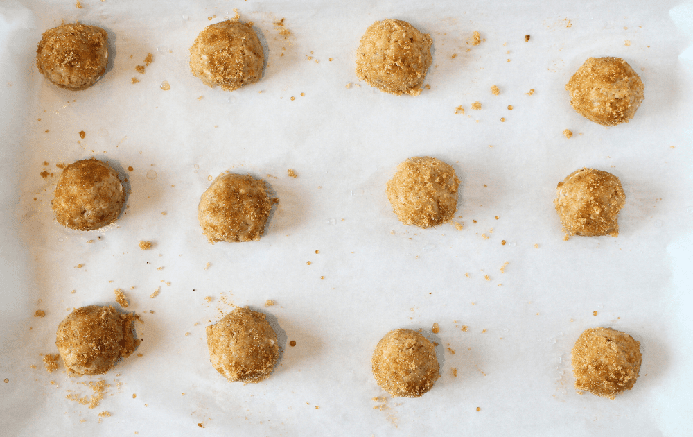top view of easy keto ginger cookies that have been dampened with wet fingers and rolled in brown sweetener before being baked