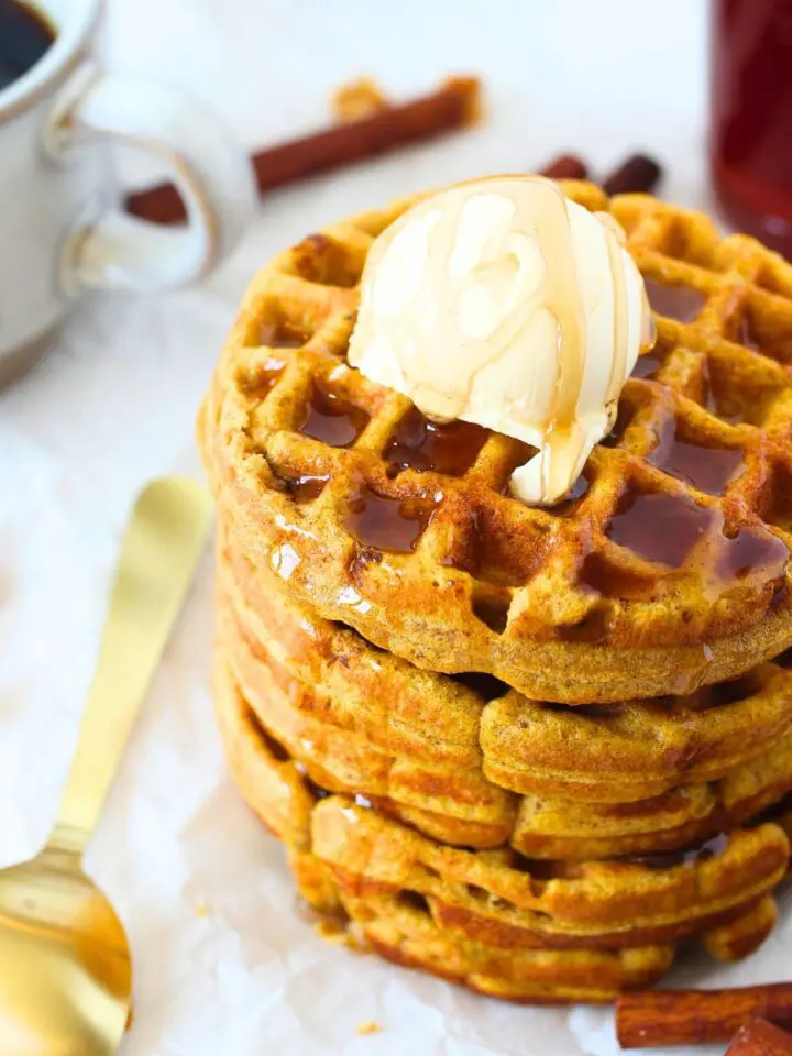 keto mini pumpkin waffles stacked on top of each other with melted butter and sugar-free maple syrup