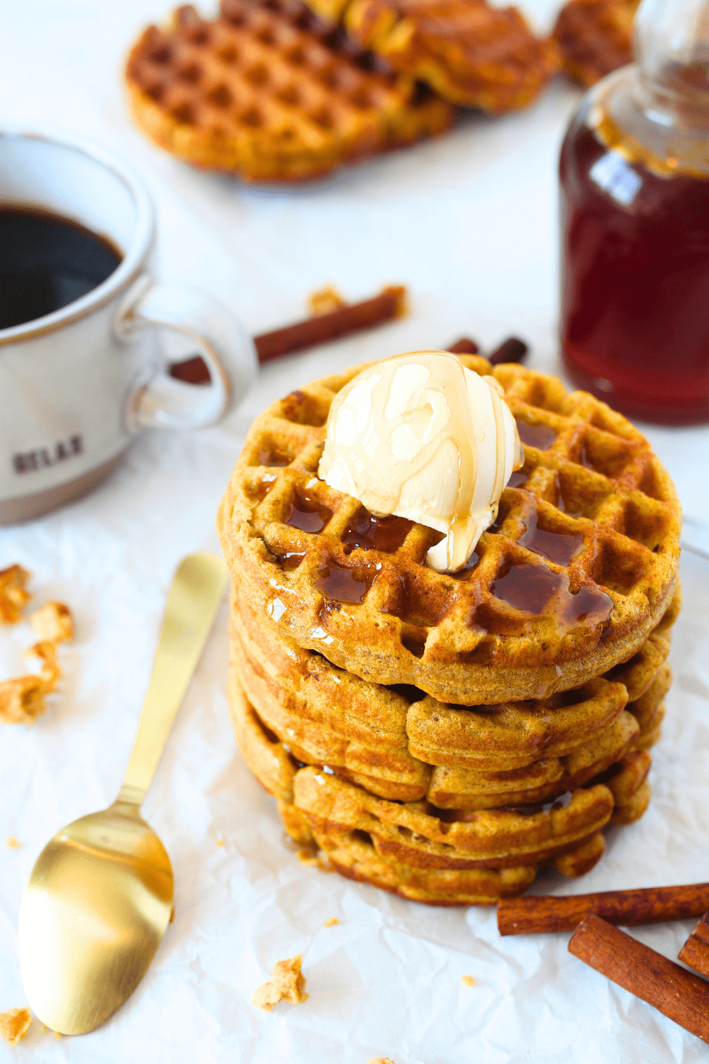 keto mini pumpkin waffles stacked on top of each other with melted butter and sugar-free maple syrup