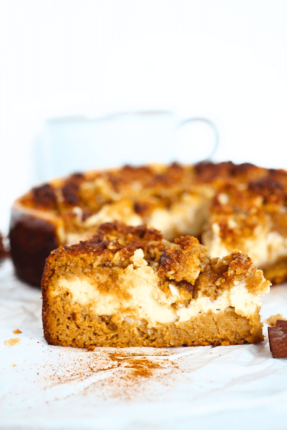 a slice of a keto pumpkin cake with a cream cheese filling and topped with a keto crumb 