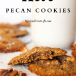 Keto pecan cookies scattered about with a glass of almond milk in the background and pecans scattered around the keto holiday cookies