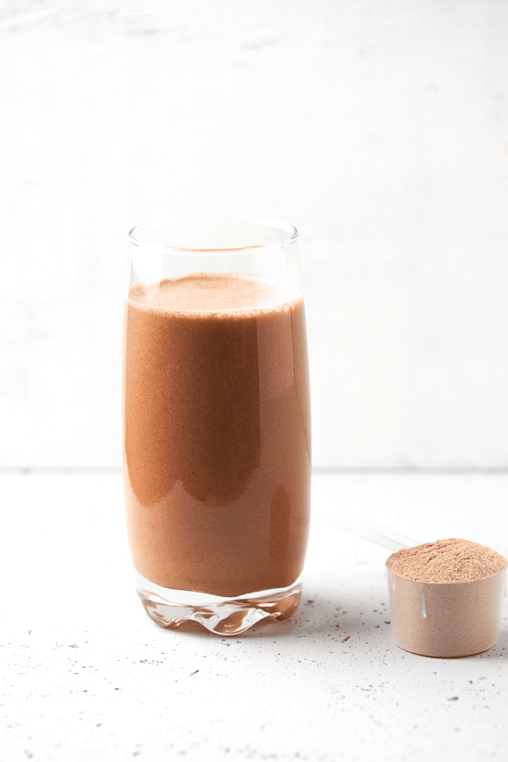 a clear glass with the best protein shake that is keto friendly with a scoop of protein powder