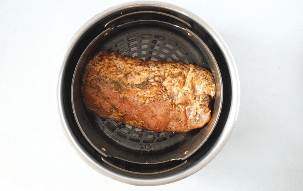 Smithfield marinated herb and garlic pork tenderloin placed raw in the air fryer basket