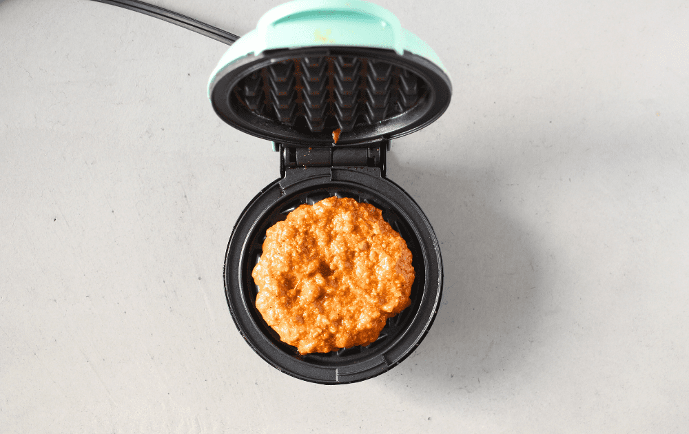 mini keto waffle maker with carnivore waffle batter before being cooked