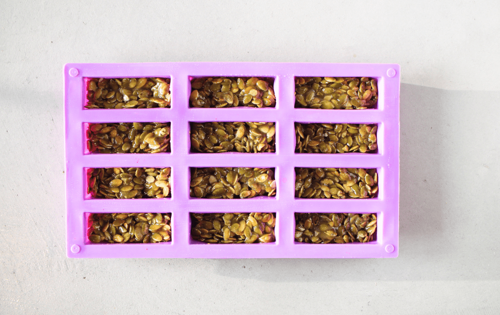 keto pumpkin seed protein bars divided into 12 and pressed into a candy bar mold before being baked