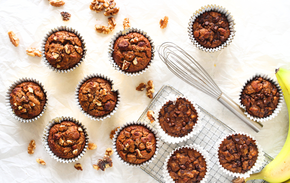low calorie muffins after being baked with walnuts and a whisk in the background