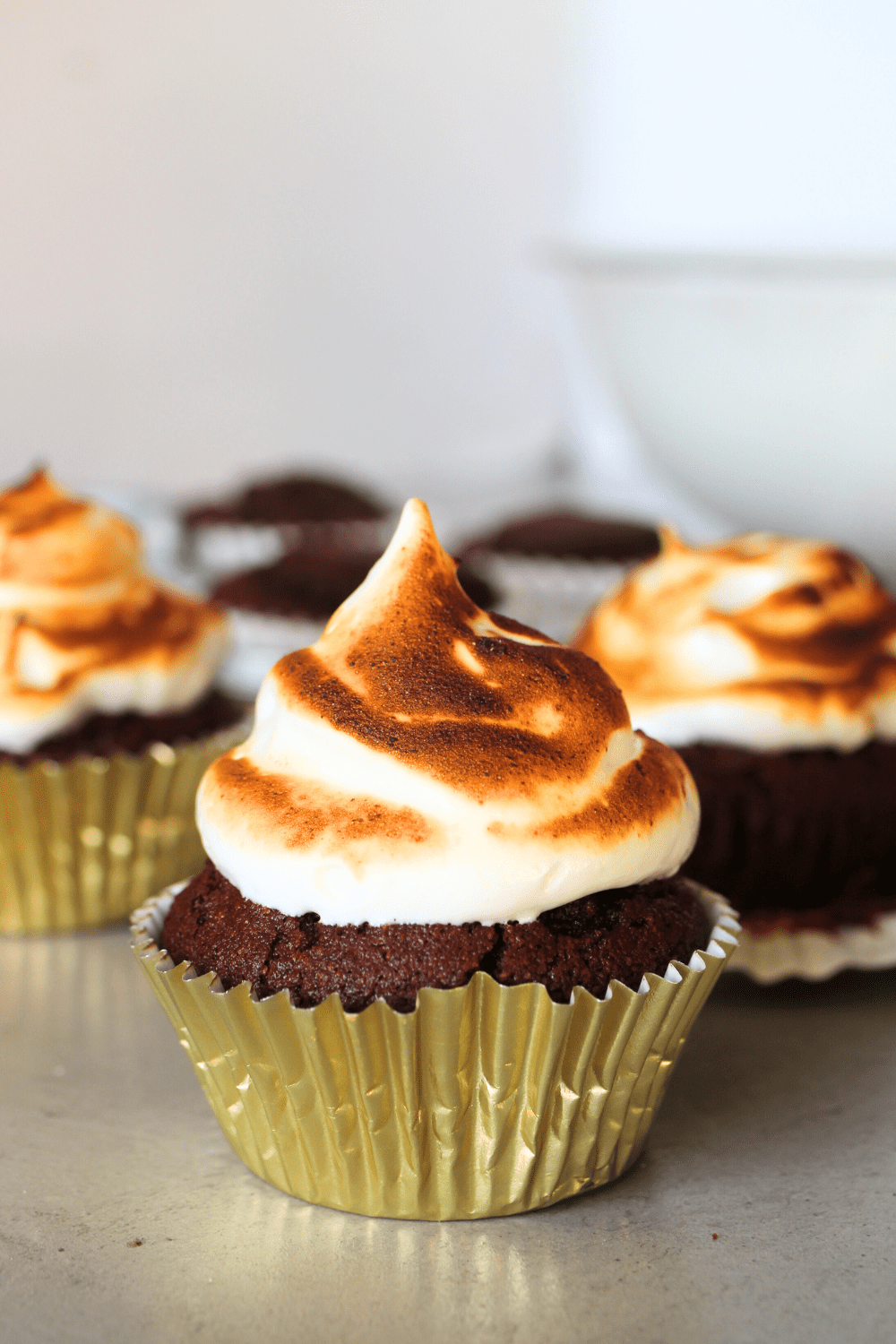 a keto chocolate cupcake topped with keto marshmallow fluff that has been roasted.