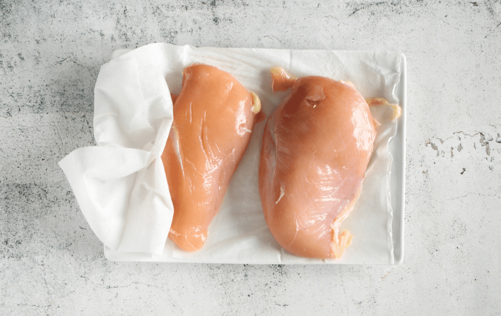top view of brined chicken recipe being patted dry after having been brined for 30 minutes