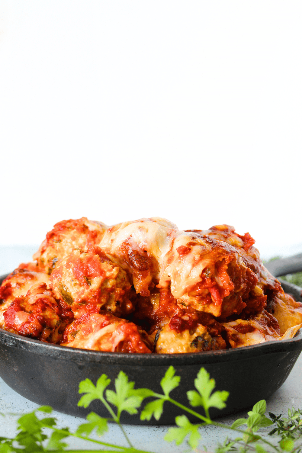 keto pork and ricotta meatball in a skillet with melted cheese