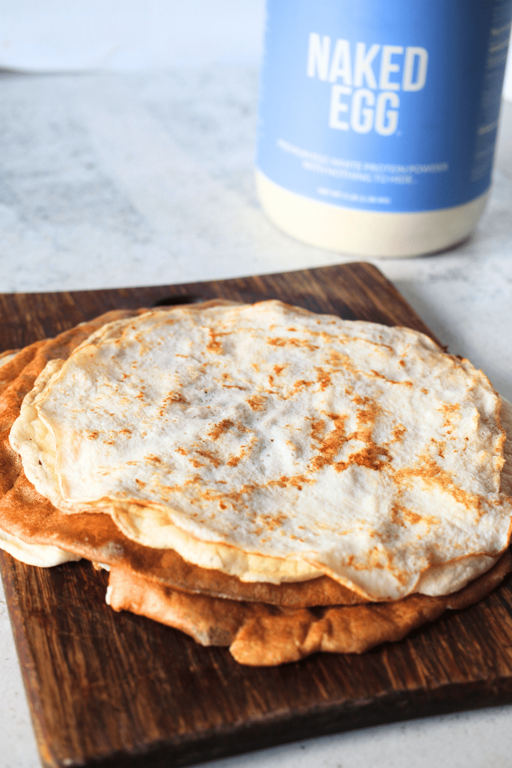 a pure protein recipe made up of crepes that are stacked on top of each other.  I canister of Naked Egg white protein powder is in the background