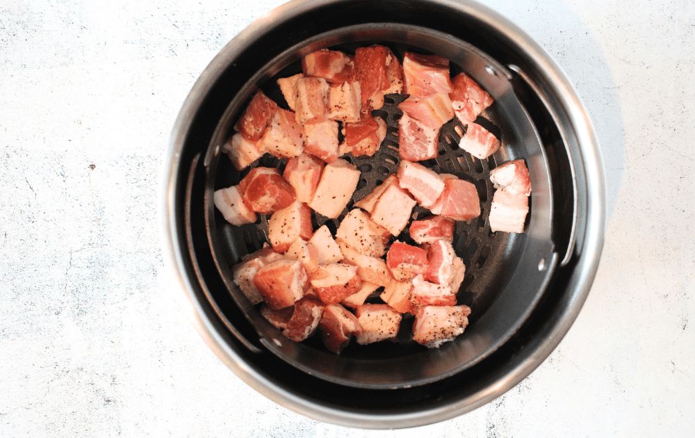 top view of air fryer basket filled with carnivore pork belly