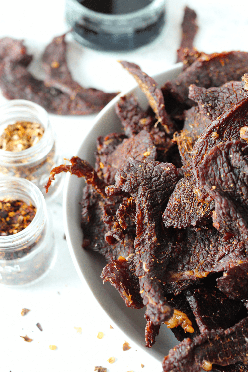 a bowl of sugar-free homemade air fryer jerky recipe with spices and soy sauce 