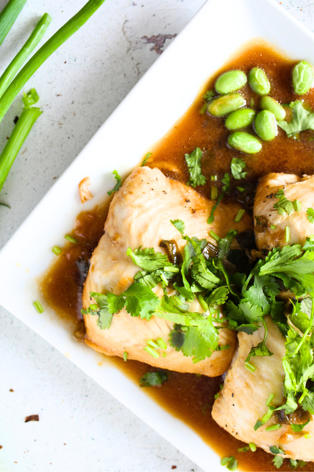 instant pot fish recipe with ginger soy dressing on a serving plate with cilantro and green onions