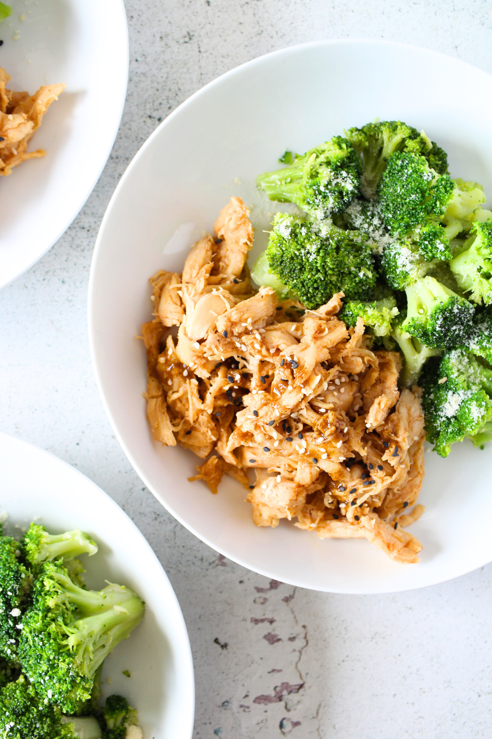 3 bowls containing PSMF Sweet and Spicy slow cooker chicken with a side of broccoli