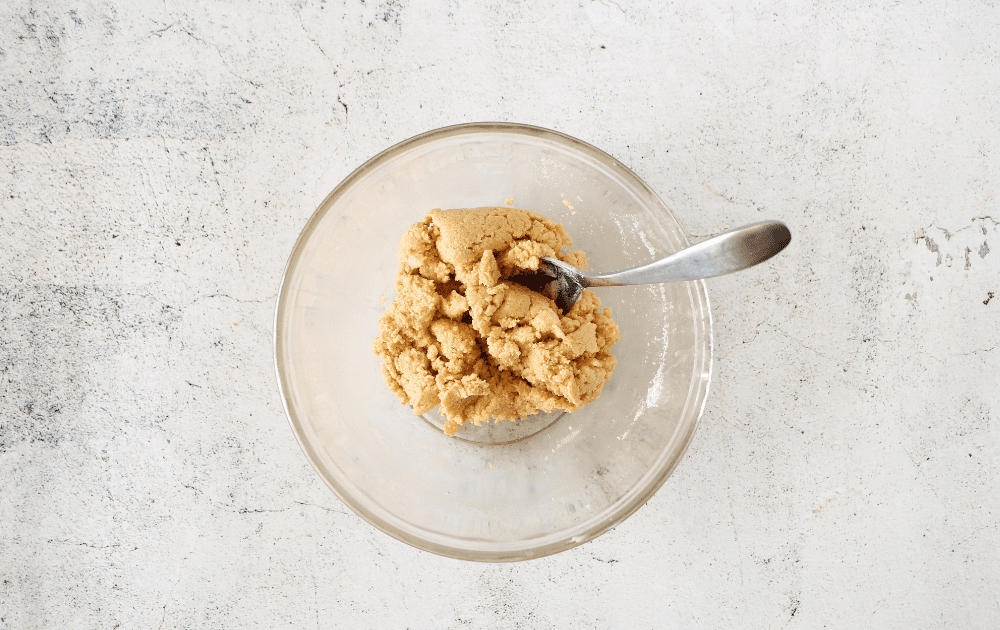top view of mixed keto no-bake cookie ingredients combined with a spoon