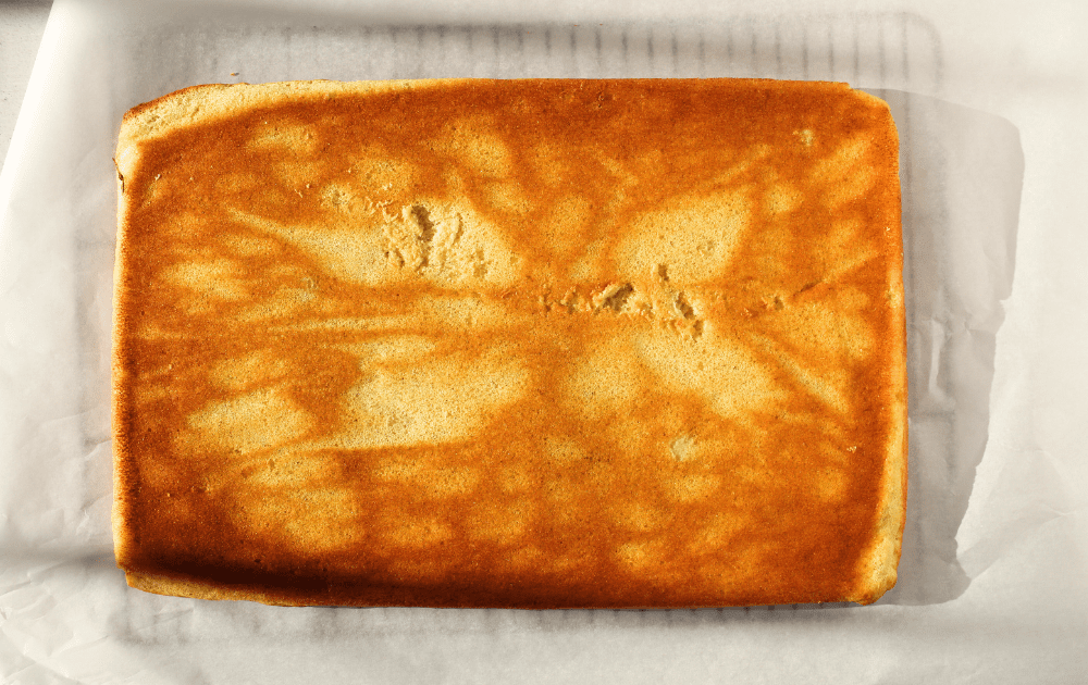 top view of banana roll cake after being flipped over onto parchment paper